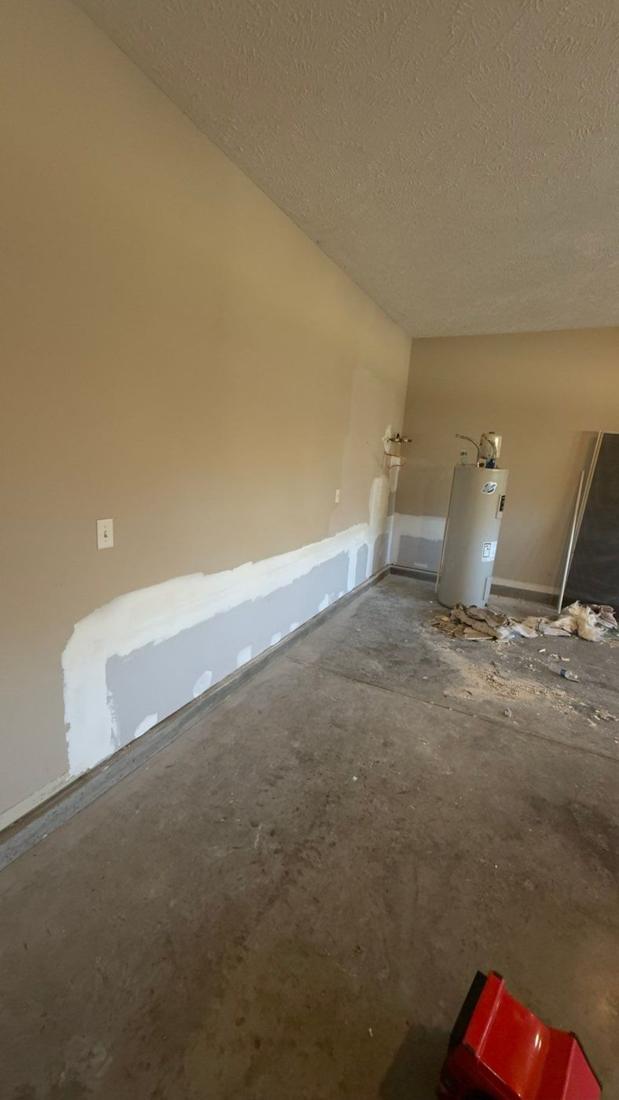 Patched drywall along the bottom of a garage wall