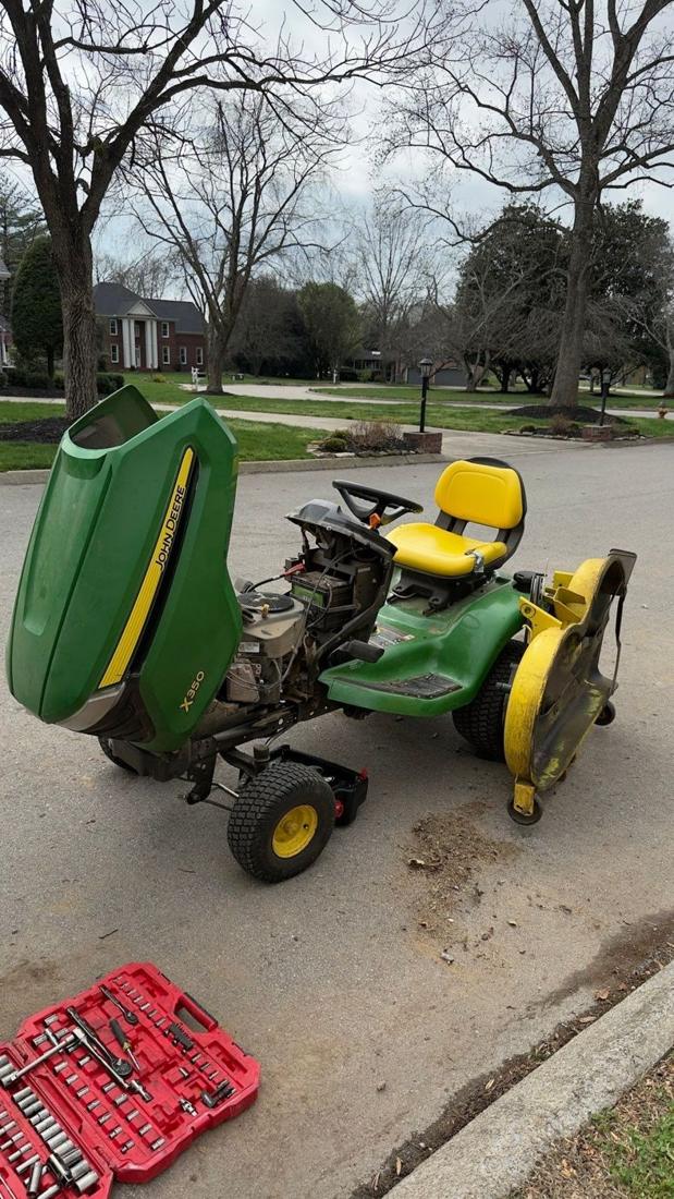 John Deere riding mower with hood open during repair